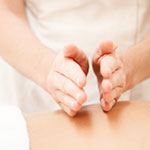 Massage therapist using percussion and jostling techniques on a client’s back during a myofascial massage to ease muscle tension and improve mobility at Spirit & Body Massage Prescott Valley.